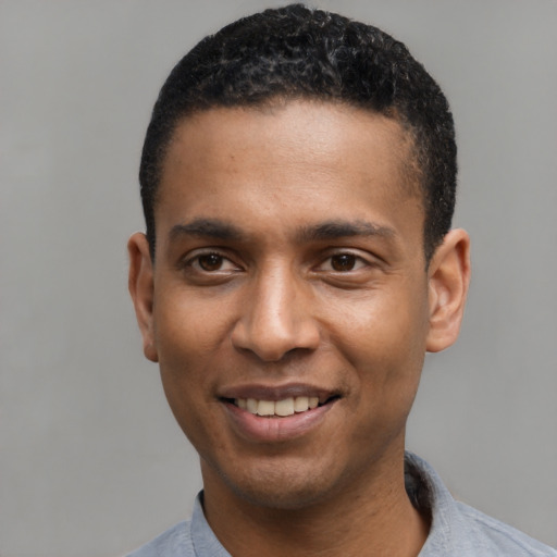 Joyful latino young-adult male with short  black hair and brown eyes