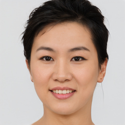 Joyful asian young-adult female with short  brown hair and brown eyes