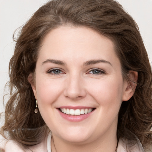 Joyful white young-adult female with long  brown hair and grey eyes