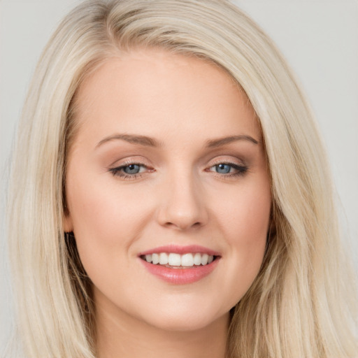 Joyful white young-adult female with long  brown hair and blue eyes