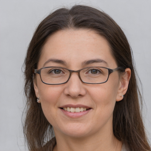 Joyful white adult female with long  brown hair and grey eyes