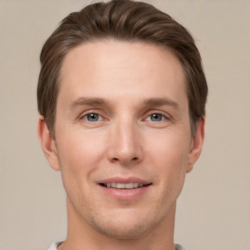 Joyful white young-adult male with short  brown hair and grey eyes