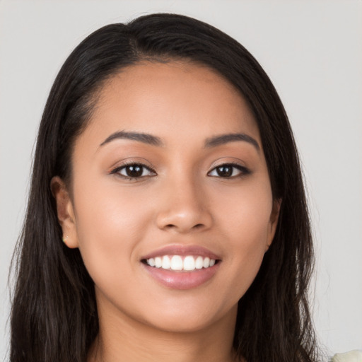 Joyful latino young-adult female with long  black hair and brown eyes