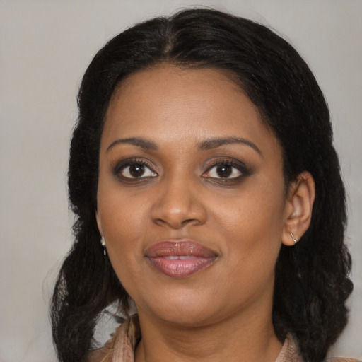 Joyful black young-adult female with long  black hair and brown eyes