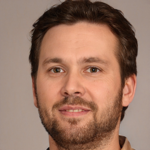 Joyful white adult male with short  brown hair and brown eyes