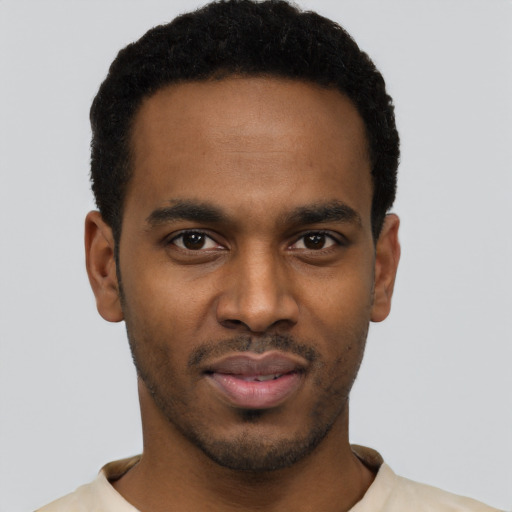 Joyful black young-adult male with short  black hair and brown eyes