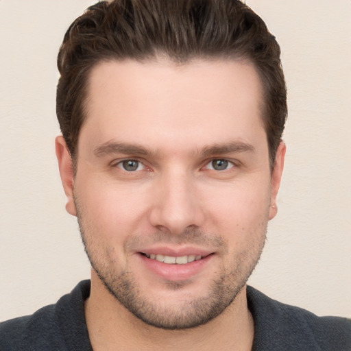 Joyful white young-adult male with short  brown hair and grey eyes