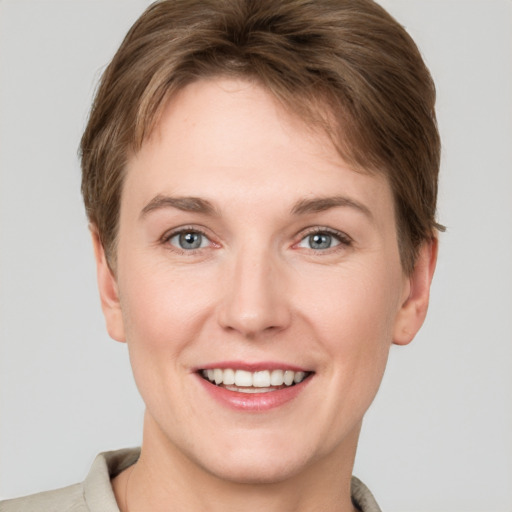 Joyful white young-adult female with short  brown hair and grey eyes