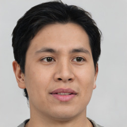 Joyful asian young-adult male with short  brown hair and brown eyes