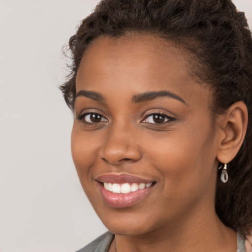 Joyful black young-adult female with medium  brown hair and brown eyes