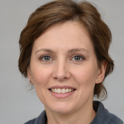 Joyful white adult female with medium  brown hair and grey eyes