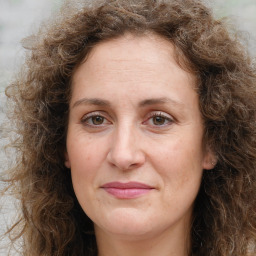 Joyful white adult female with long  brown hair and brown eyes