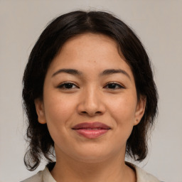 Joyful latino young-adult female with medium  brown hair and brown eyes