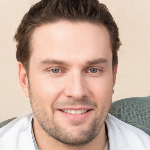 Joyful white young-adult male with short  brown hair and grey eyes