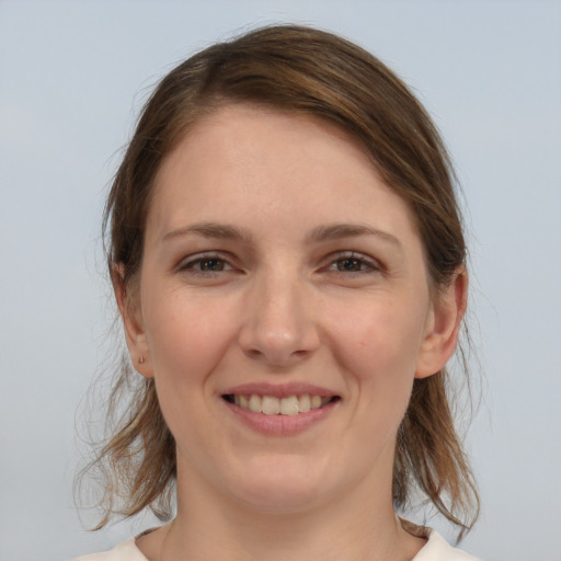 Joyful white young-adult female with medium  brown hair and grey eyes