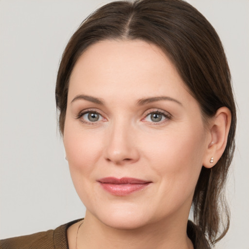 Joyful white young-adult female with medium  brown hair and grey eyes