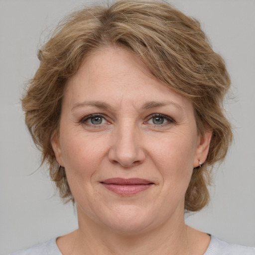 Joyful white adult female with medium  brown hair and green eyes