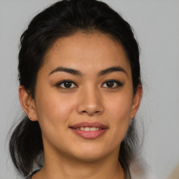 Joyful latino young-adult female with medium  brown hair and brown eyes