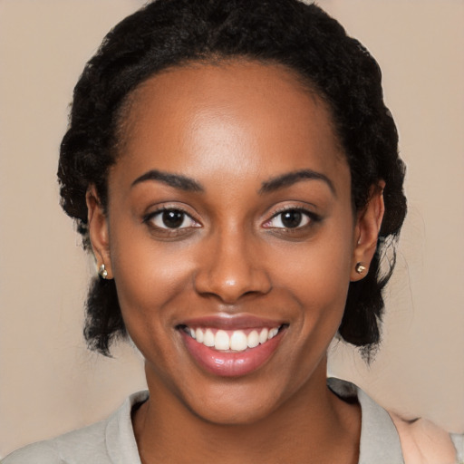 Joyful black young-adult female with medium  black hair and brown eyes