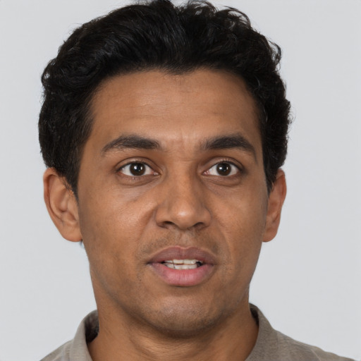 Joyful latino adult male with short  brown hair and brown eyes