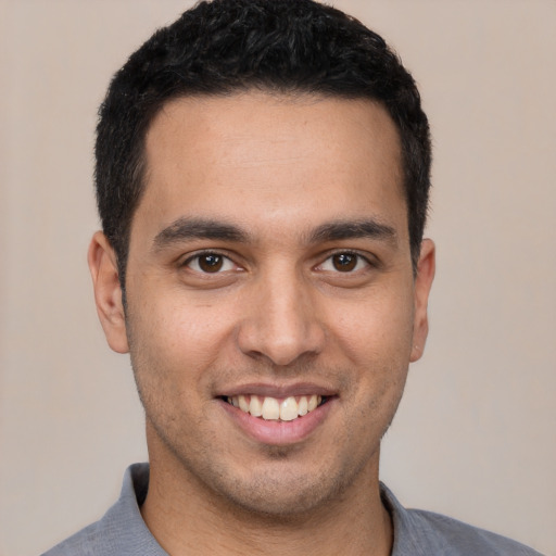 Joyful white young-adult male with short  black hair and brown eyes