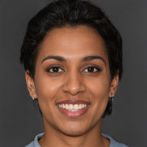 Joyful black young-adult female with short  brown hair and brown eyes