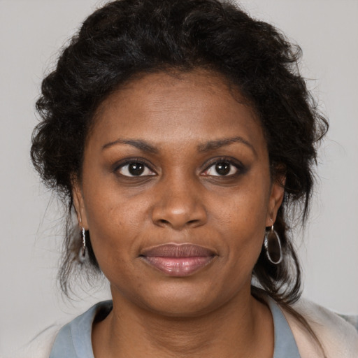 Joyful black young-adult female with medium  brown hair and brown eyes