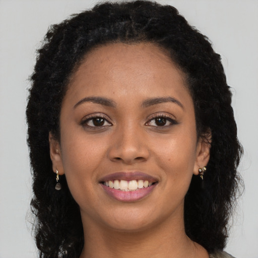 Joyful latino young-adult female with long  brown hair and brown eyes