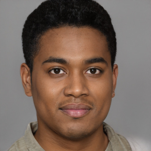 Joyful black young-adult male with short  brown hair and brown eyes