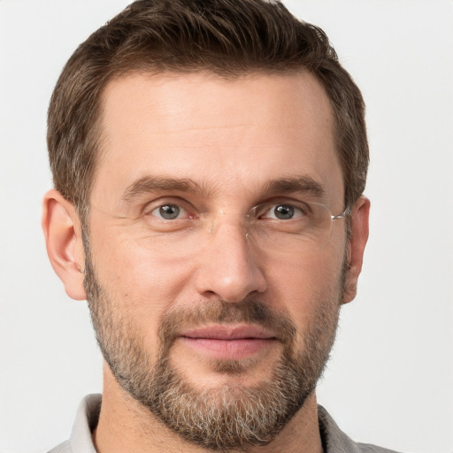 Joyful white adult male with short  brown hair and grey eyes