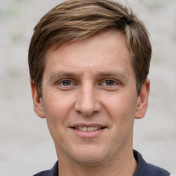 Joyful white adult male with short  brown hair and grey eyes