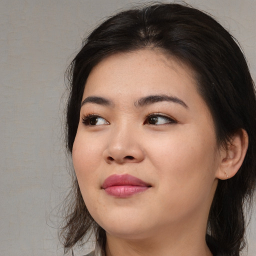 Joyful asian young-adult female with long  black hair and brown eyes