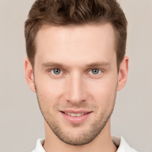 Joyful white young-adult male with short  brown hair and grey eyes