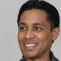 Joyful latino young-adult male with short  black hair and brown eyes