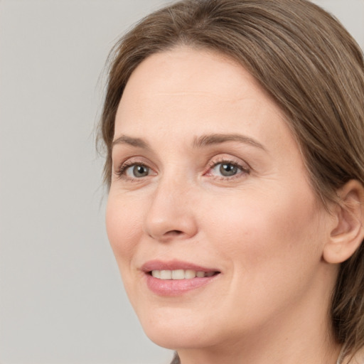 Joyful white adult female with medium  brown hair and grey eyes