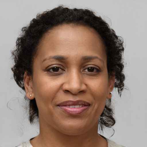 Joyful black adult female with medium  brown hair and brown eyes