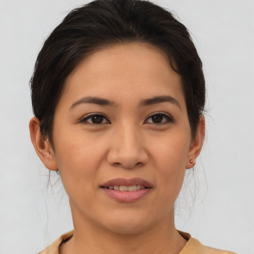 Joyful latino young-adult female with medium  brown hair and brown eyes