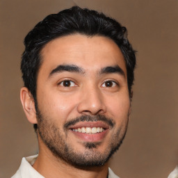 Joyful latino young-adult male with short  black hair and brown eyes
