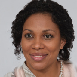 Joyful black adult female with medium  brown hair and brown eyes