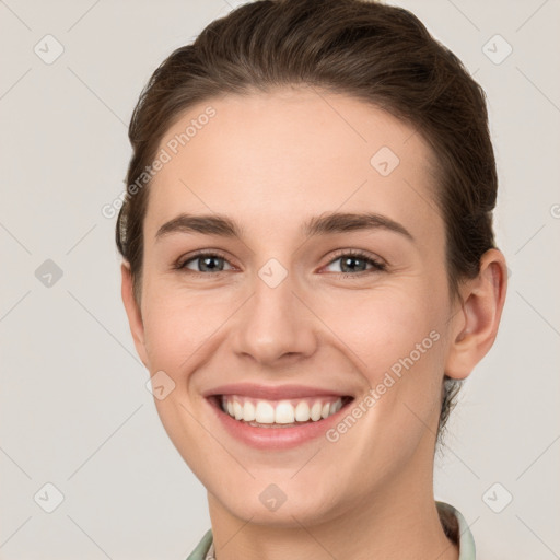 Joyful white young-adult female with short  brown hair and grey eyes