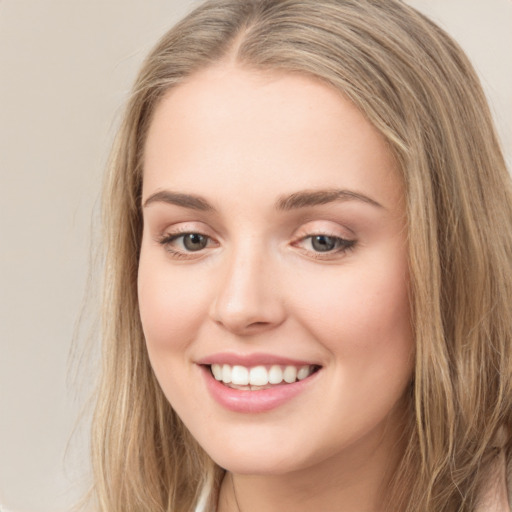 Joyful white young-adult female with long  brown hair and green eyes