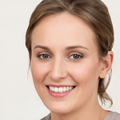 Joyful white young-adult female with medium  brown hair and blue eyes