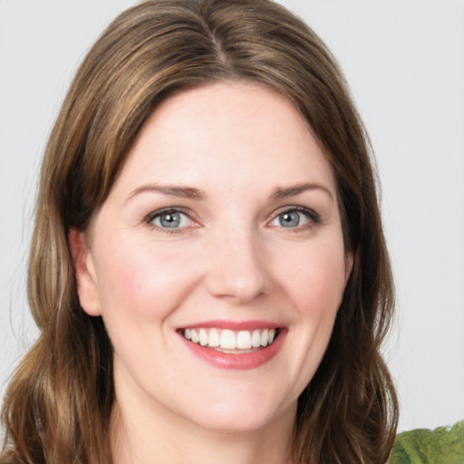 Joyful white young-adult female with medium  brown hair and green eyes