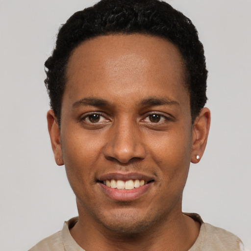 Joyful black young-adult male with short  black hair and brown eyes