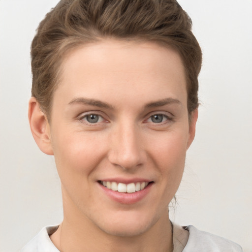 Joyful white young-adult female with short  brown hair and grey eyes