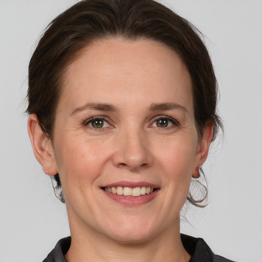 Joyful white adult female with medium  brown hair and grey eyes