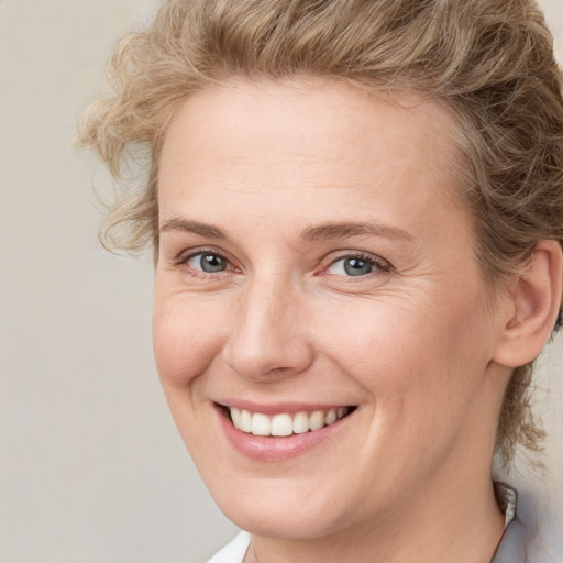 Joyful white young-adult female with medium  brown hair and blue eyes