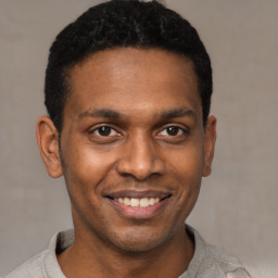 Joyful latino young-adult male with short  black hair and brown eyes