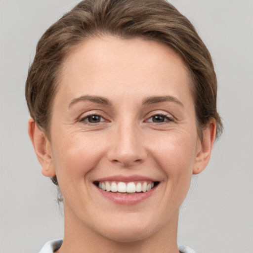 Joyful white young-adult female with short  brown hair and grey eyes