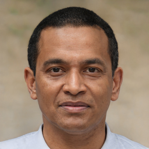 Joyful black adult male with short  black hair and brown eyes